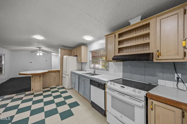 a kitchen with a sink a stove and cabinets