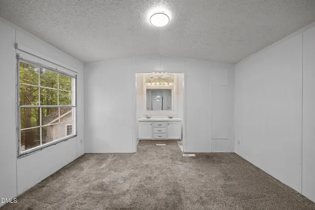 an empty room with windows and cabinet