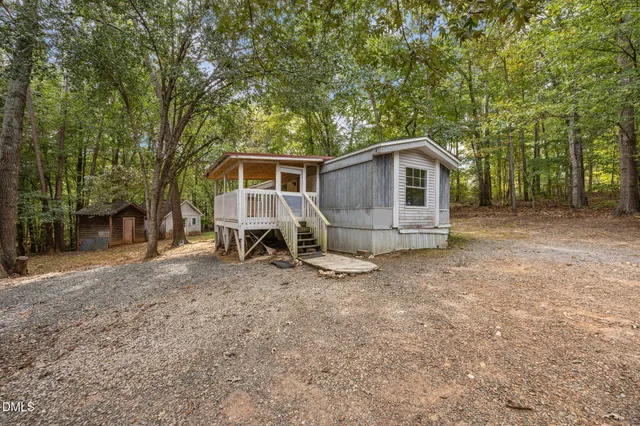 a view of a house with a yard and large tree