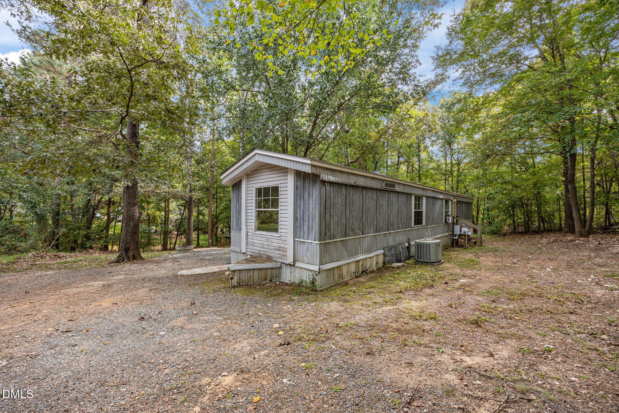 6933 Big Woods Road Graham, NC 27253 - Photo 6 of 32 a view of a barn in the backyard with large tree and wooden fence