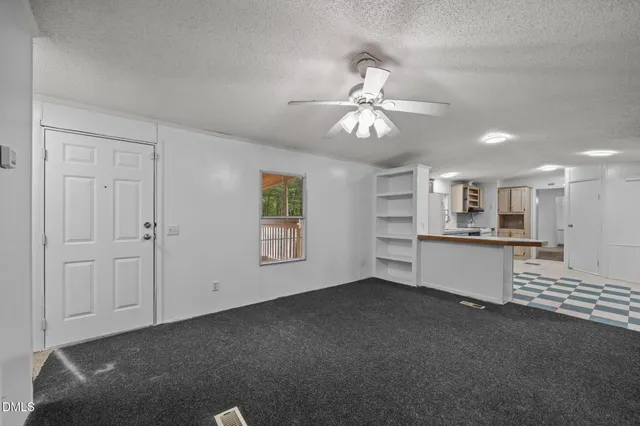a view of an empty room with window and cabinet