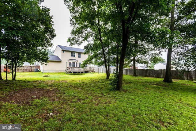 a view of a house with a big yard and large trees