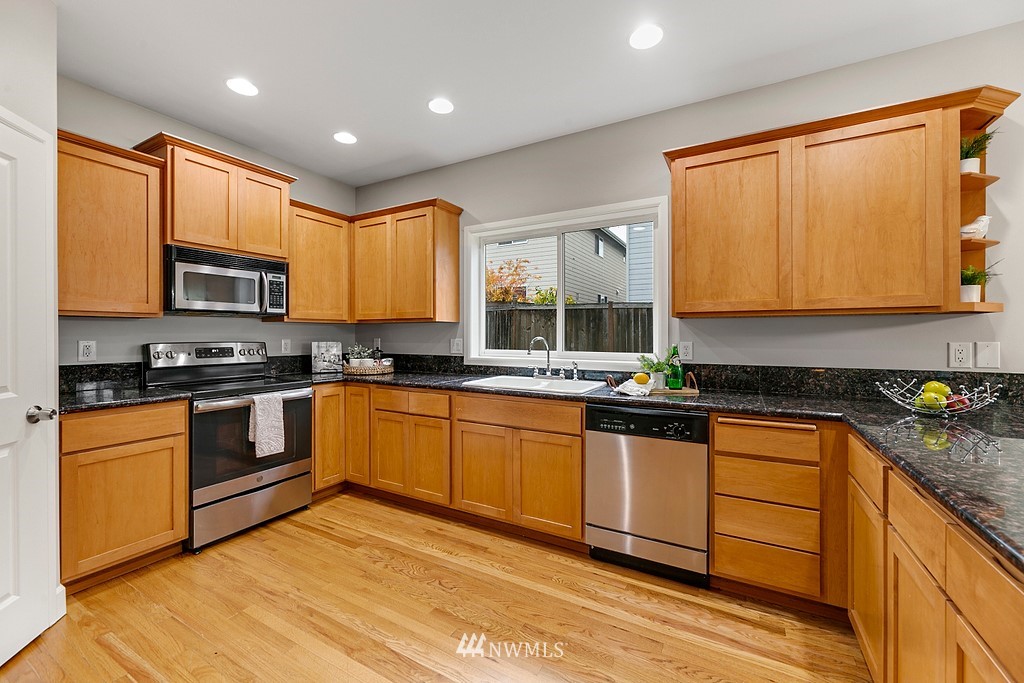 2222 Smithers Avenue South Renton, WA 98055 - Photo 9 of 25 a kitchen with stainless steel appliances granite countertop wooden cabinets a stove a sink and a microwave