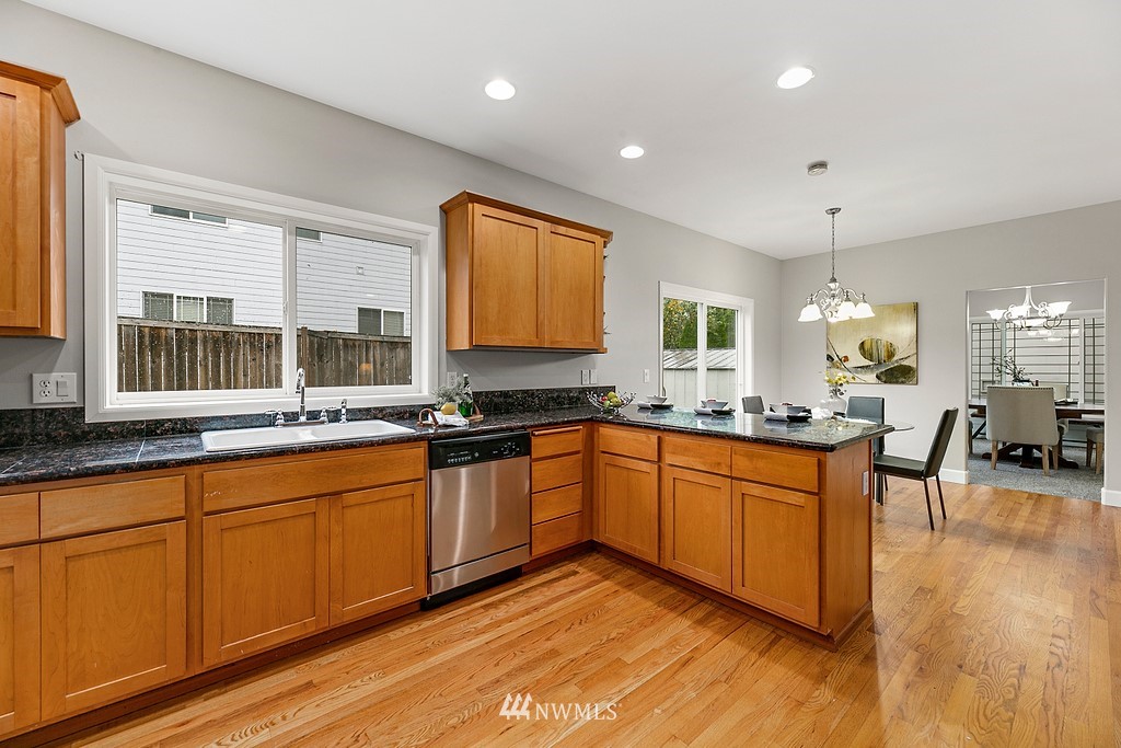 2222 Smithers Avenue South Renton, WA 98055 - Photo 10 of 25 a large kitchen with stainless steel appliances granite countertop a stove a sink a dining table and chairs