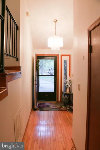 a view of an empty room with wooden floor and a fireplace