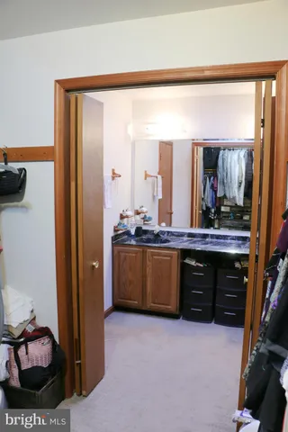 a view of a hallway with bathroom and a livingroom