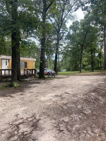 a view of a house with backyard and trees