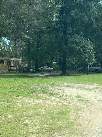 a view of a yard with a house and large trees
