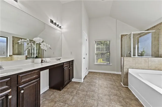 a spacious bathroom with a bathtub sink and mirror
