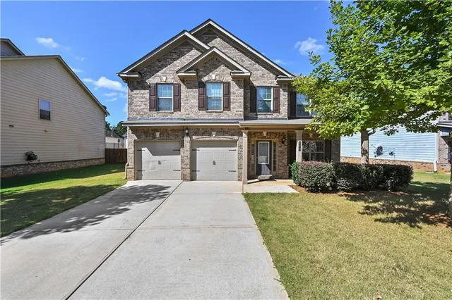a front view of a house with a yard and garage