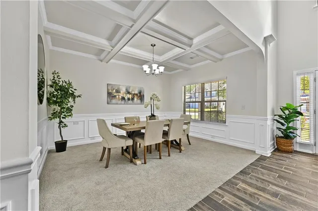a dining room with furniture potted plants and wooden floor