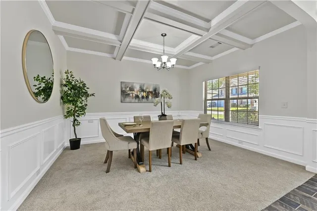 a dining room with furniture a potted plant and a chandelier fan