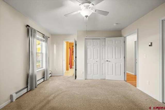a view of a livingroom with a chandelier fan and windows