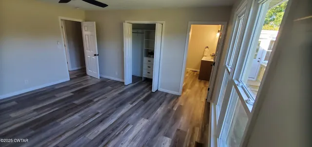 a view of a hallway with wooden floor and glass door