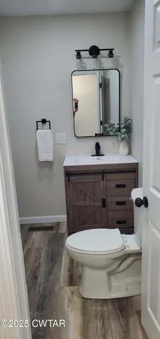 a bathroom with a toilet a sink and mirror