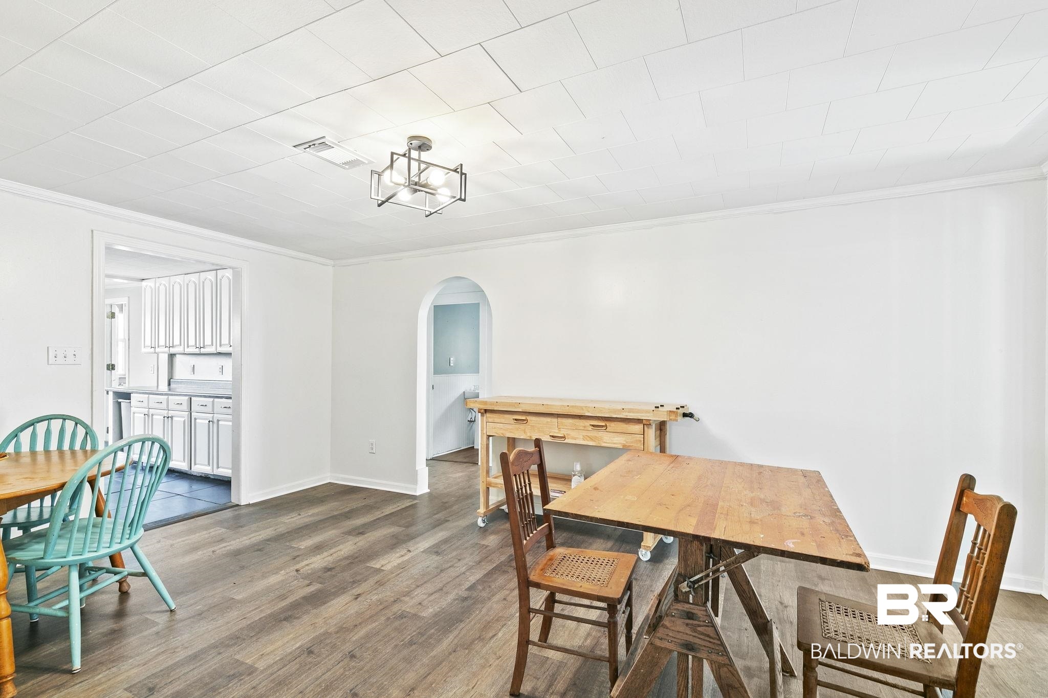 316 West Orchid Avenue Foley, AL 36535 - Photo 13 of 38 Dining space with arched walkways, crown molding, and dark wood-style flooring