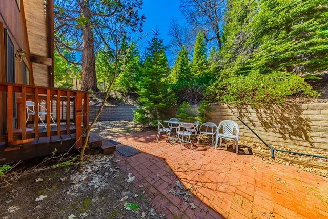a view of wooden house with a small deck and a backyard