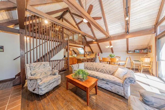 a living room with furniture a fireplace and large windows