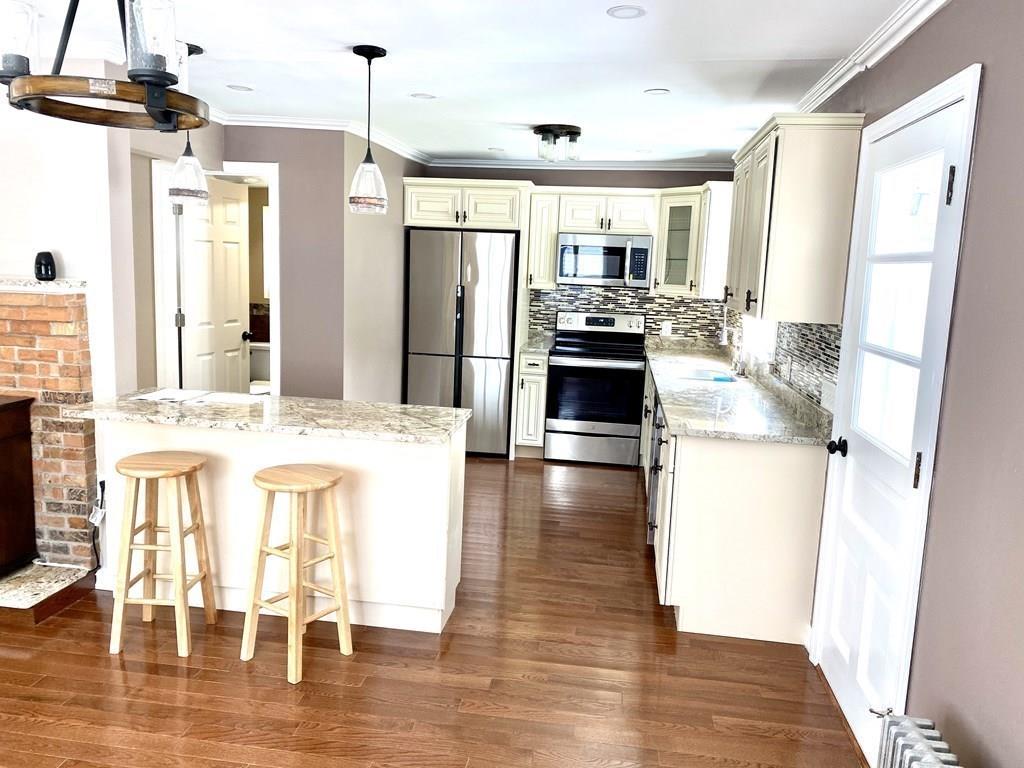 458 Gleasondale Road Stow, MA 01775 - Photo 6 of 14 a kitchen with stainless steel appliances a refrigerator and wooden floor