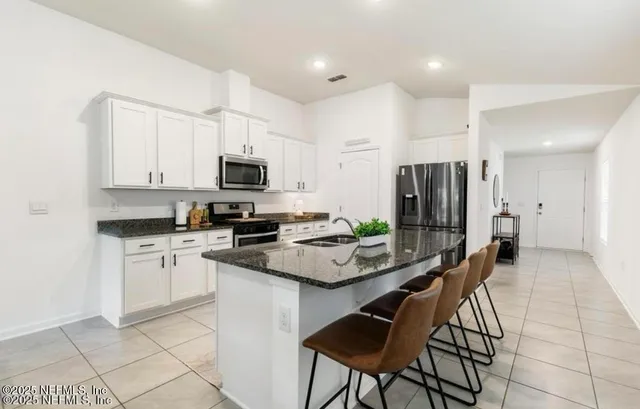 a kitchen with stainless steel appliances granite countertop a sink and a refrigerator