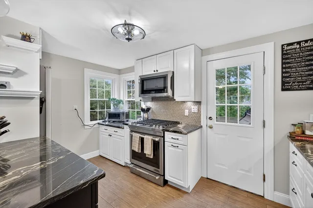 a kitchen with stainless steel appliances granite countertop a stove and a microwave
