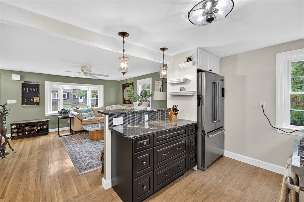 14 Ferndale Road Natick, MA 01760 - Photo 15 of 33 a kitchen with stainless steel appliances granite countertop a refrigerator a sink dishwasher a stove and a dining table with wooden floor