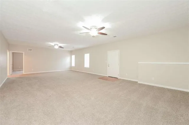 an empty room with a window and a ceiling fan