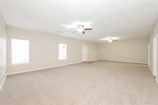 a view of an empty room with a ceiling fan