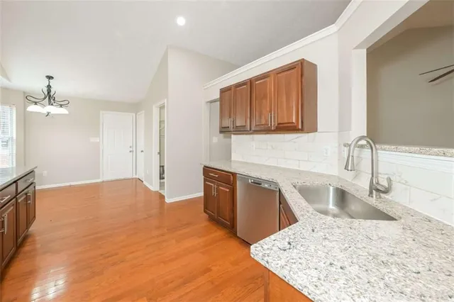 an empty room with wooden floor ceiling fan and windows