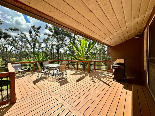 a view of a house with a big yard and large trees