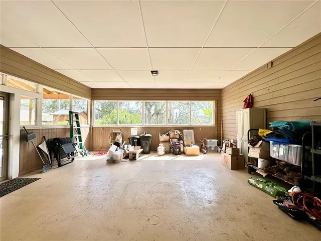 a view of an swimming pool with a yard and large trees