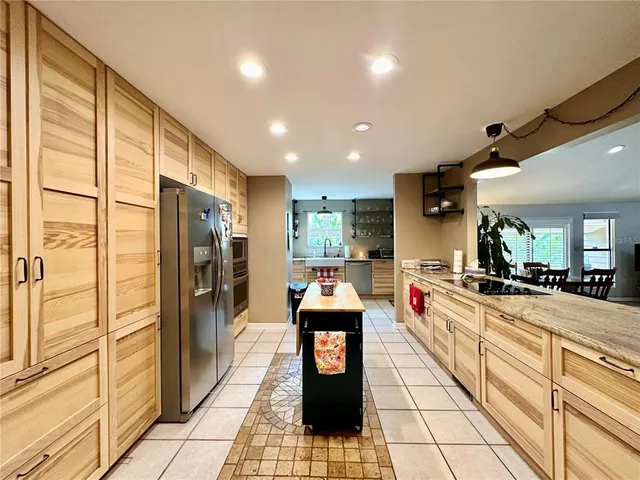 a kitchen with a refrigerator and wooden floor