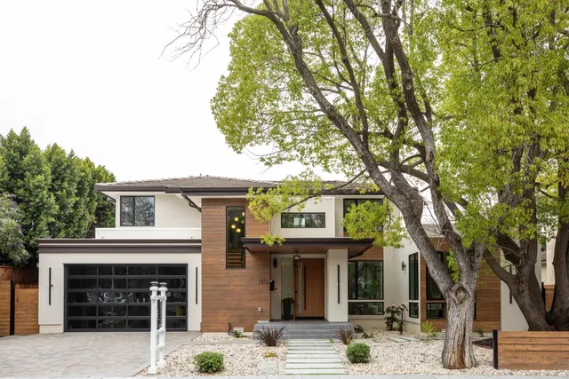 a front view of a house with a tree