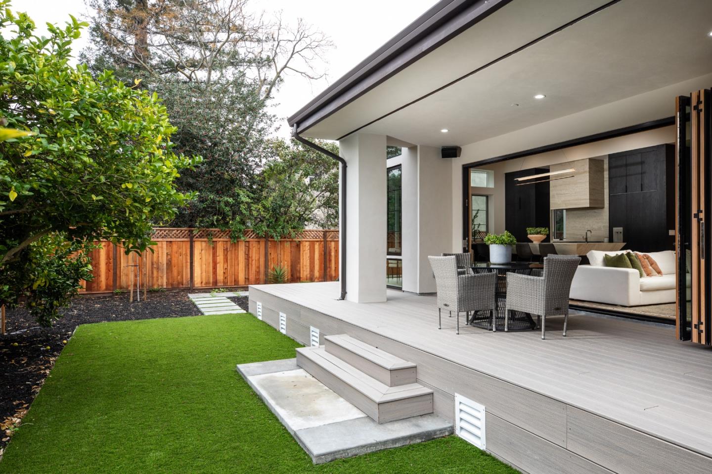 3413 Ross Road Palo Alto, CA 94303 - Photo 43 of 45 a view of a patio with couches table and chairs with plants and wooden fence