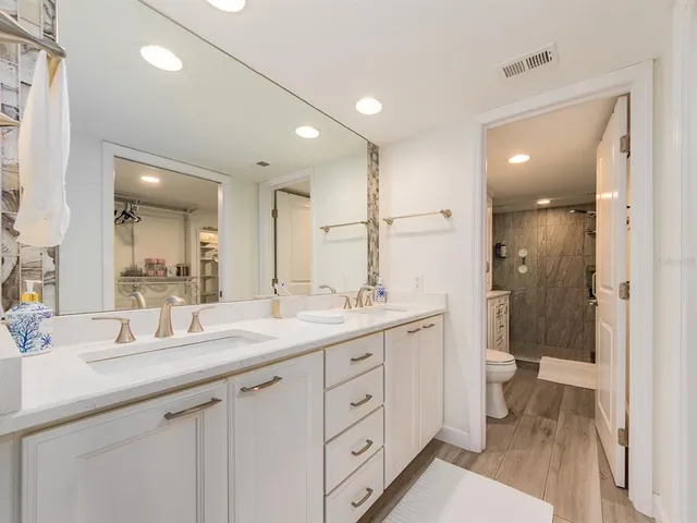 a bathroom with a double vanity sink mirror and toilet