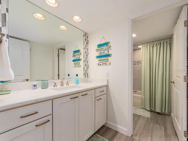 a bathroom with a double vanity sink mirror and shower