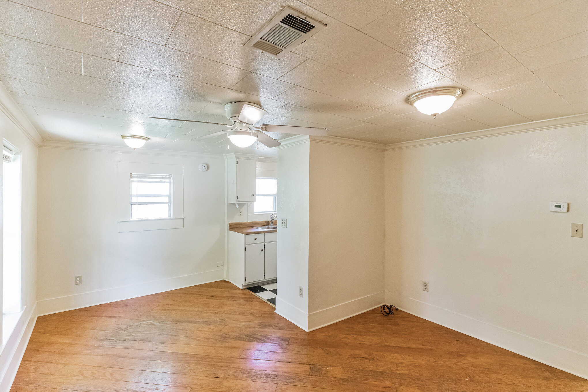 501 East 4th Street Georgetown, TX 78626 - Photo 8 of 25 Spare room featuring light wood finished floors, crown molding, and ceiling fan