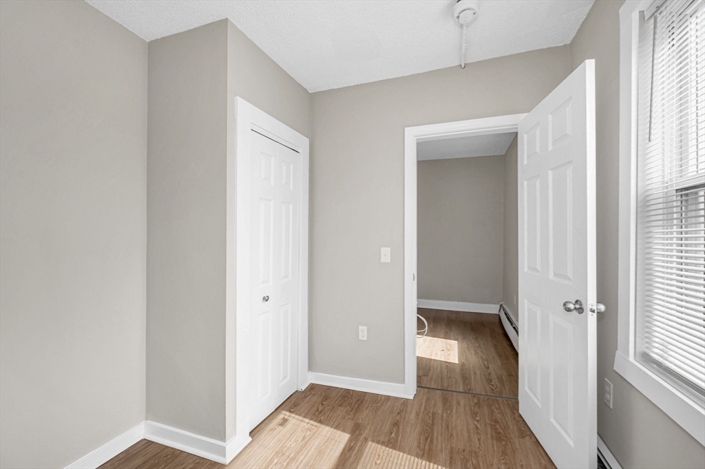 50 1/2 Common Street, Unit 5 Lawrence, MA 01840 - Photo 11 of 18 a view of a hallway with wooden floor and a bathroom