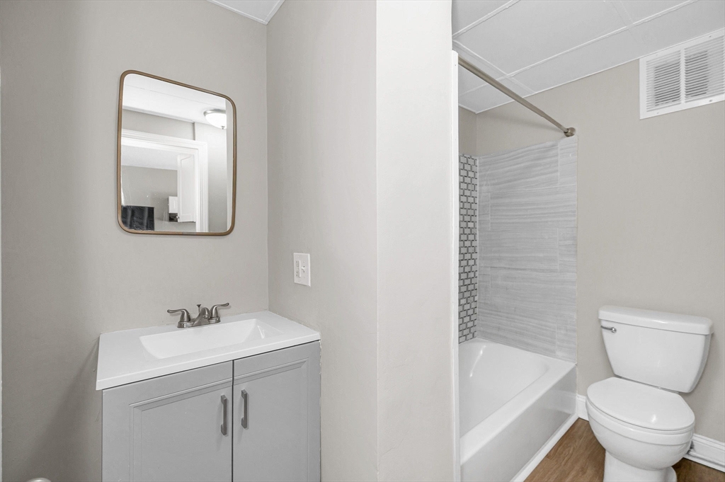 50 1/2 Common Street, Unit 5 Lawrence, MA 01840 - Photo 13 of 18 a bathroom with a toilet sink and mirror
