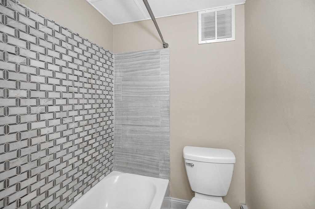 50 1/2 Common Street, Unit 5 Lawrence, MA 01840 - Photo 14 of 18 a bathroom with a toilet and a shower curtain