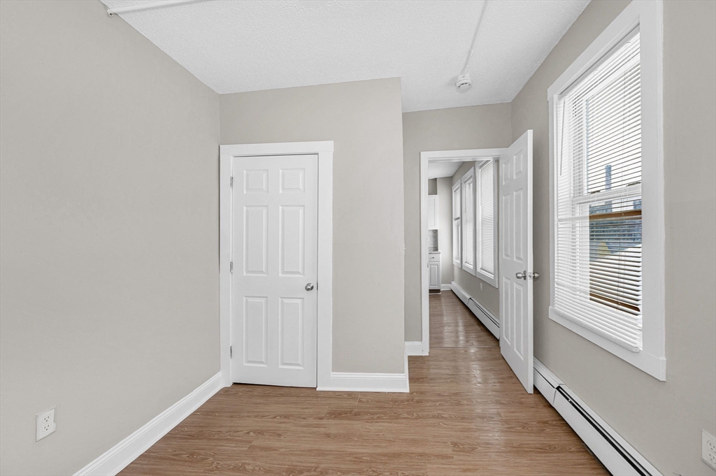 50 1/2 Common Street, Unit 5 Lawrence, MA 01840 - Photo 16 of 18 a view of a hallway with wooden floor and staircase