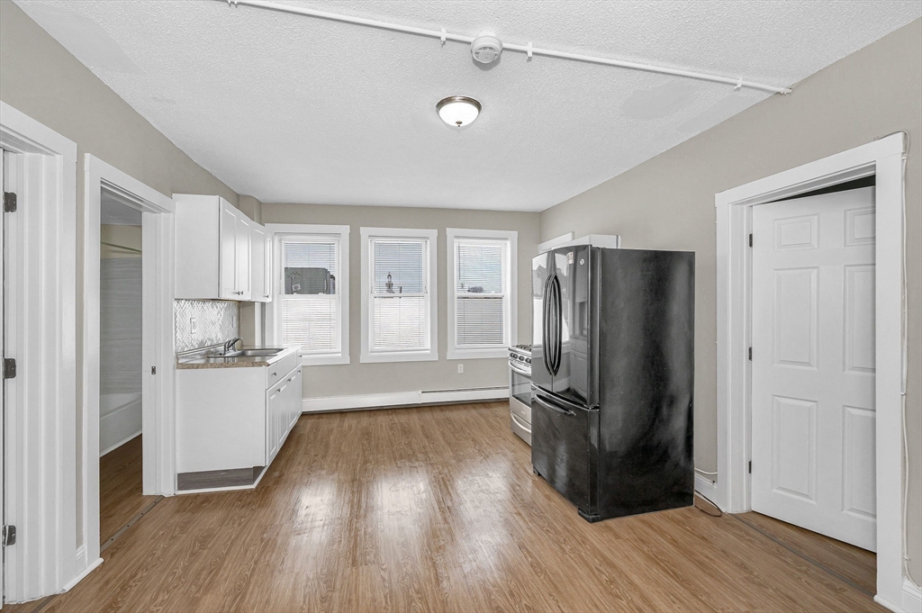 50 1/2 Common Street, Unit 5 Lawrence, MA 01840 - Photo 4 of 18 a kitchen with a refrigerator and a stove top oven