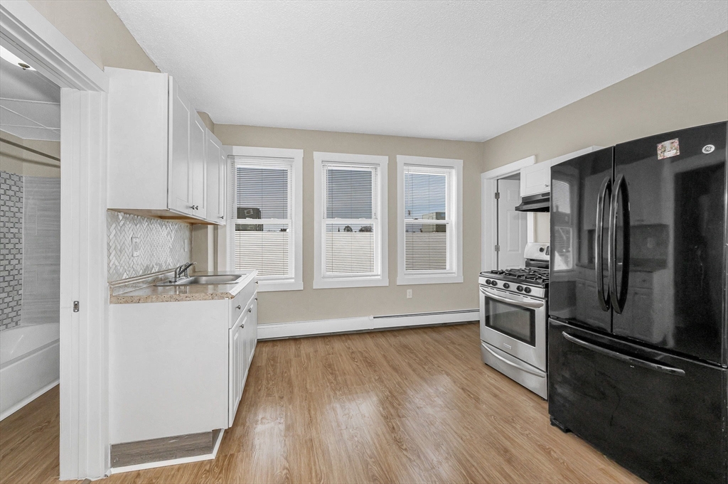 50 1/2 Common Street, Unit 5 Lawrence, MA 01840 - Photo 5 of 18 a kitchen with granite countertop a refrigerator and a stove top oven
