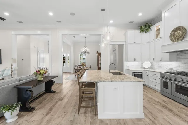 a view of a dining room with furniture a chandelier and wooden floor