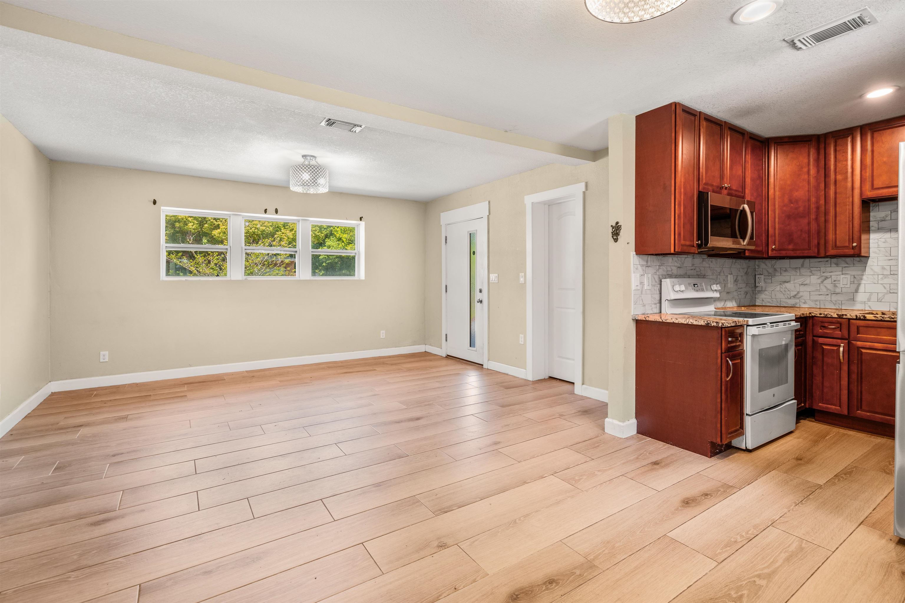 227 North Whitney Street St. Augustine, FL 32084 - Photo 5 of 35 a view of kitchen with stainless steel appliances granite countertop a stove a sink dishwasher and a refrigerator with wooden floor