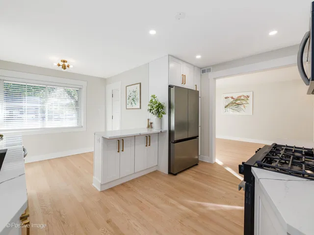 a kitchen with stainless steel appliances a refrigerator and a stove top oven