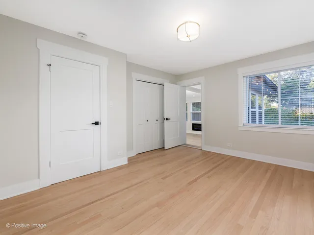 a view of empty room with wooden floor and windows