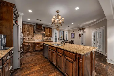 a large kitchen with kitchen island a large island in the center and stainless steel appliances