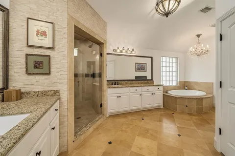 a spacious bathroom with a granite countertop sink a toilet and shower