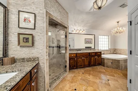 a spacious bathroom with a granite countertop sink a toilet a mirror and shower